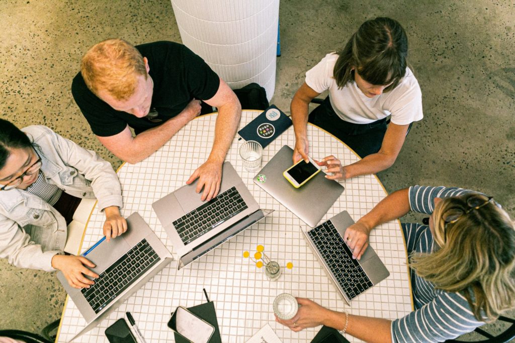 team members working at a table with computers and phones