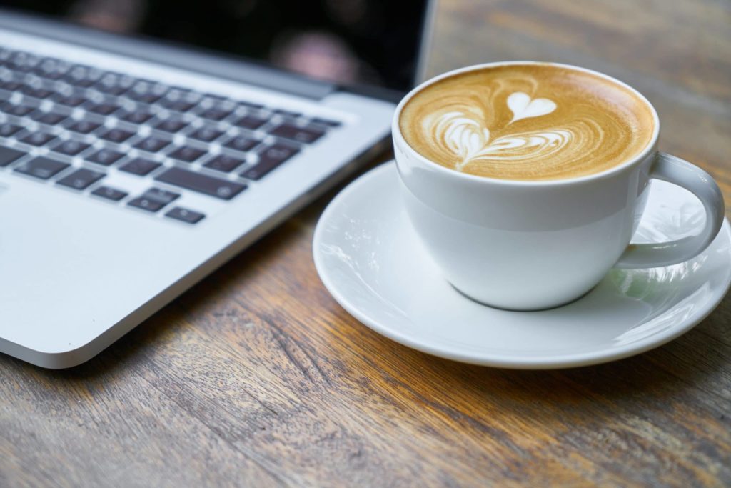 picture of latte coffee art and a laptop computer