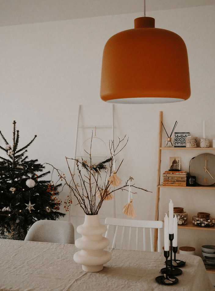 bohemian home decor with an orange lap and a Christmas tree 